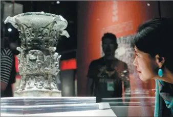  ?? XIE MINGGANG / FOR CHINA DAILY ?? A visitor examines He Zun, a bronze wine vessel at Chengdu Museum in Chengdu, Sichuan province. The bronze exhibition, which contains more than 250 antiques from Shaanxi and Sichuan provinces, opened on Monday and will run until Nov 11.