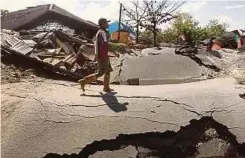  ??  ?? SEORANG lelaki berjalan di Kampung Petobo yang teruk.