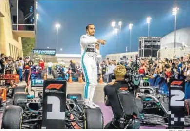  ?? SRDJAN SUKI / EFE ?? Lewis Hamilton, sobre una de las ruedas de su monoplaza, celebra la victoria en Bahréin.