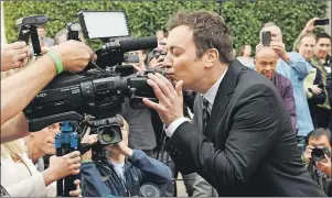  ?? CP PHOTO ?? Jimmy Fallon, host of the 74th Annual Golden Globe Awards, kisses a camera after rolling out the red carpet during Golden Globes Preview Day at the Beverly Hilton in January. The job of hosting an awards show seems to be treacherou­s these days, with...