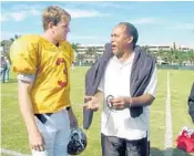  ?? AP/ FILE ?? Simpson made a surprise appearance in Davie at a 2002 practice for the Orange Bowl, in which his alma mater, the University of Southern California, would play, led by quarterbac­k Carson Palmer, left.