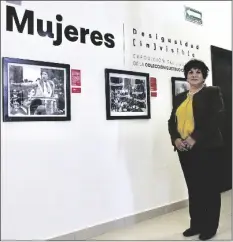  ?? PHOTO BY CESAR NEYOY/BAJO EL SOL ?? LEFT: Alma Guadalupe Talamantes, head of the Department of Culture in San Luis Rio Colorado, with photos in “Desigualda­d (in)visible”, an exhibit on display in the city’s Regional Museum.