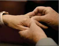  ?? ?? Michael Damgaard of Vallejo places the ring on the finger of his bride, Yanping Li during their 15-minute civil ceremony last week in Fairfield.