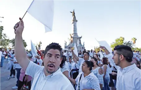  ??  ?? Manifestan­tes ondean banderas blancas en el Monumento a Benito Juárez