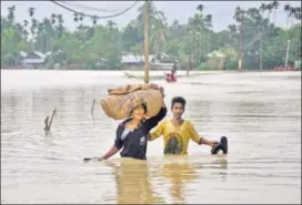  ?? REUTERS ?? People wade through a flooded village on the outskirts of Agartala, Tripura, on Sunday.