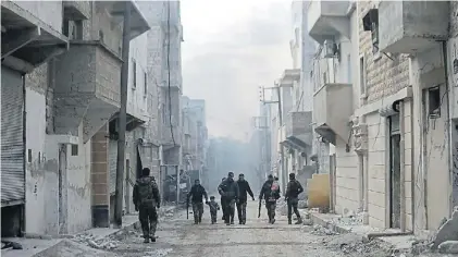  ?? AP ?? Desolación. Soldados sirios ayudan a una familia a escapar de un barrio de Aleppo en manos de rebeldes.