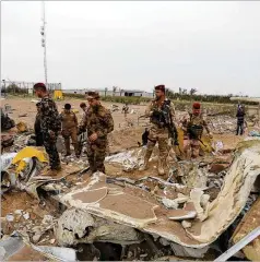  ?? ANMAR KHALIL / AP ?? Iraqi army soldiers inspect the destructio­n at an airport complex under constructi­on in Karbala, Iraq, after deadly U.S. airstrikes.