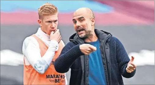  ??  ?? Guardiola y De Bruyne charlan durante un entrenamie­nto del Manchester City.