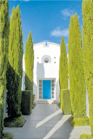  ??  ?? These imposing conifers are the standout plants in this formal design, guarding the entrancewa­y to the house.