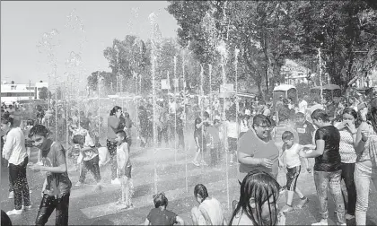  ??  ?? Habitantes de la delegación Iztapalapa disfrutan de la fuente brotante instalada en la explanada del edificio de gobierno ■ Foto Jesús Villaseca