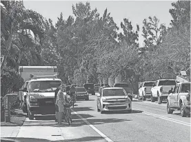  ?? PROVIDED BY JANICE HARPER ?? Cyclists waiting to enter the traffic lane on Siesta Key’s Higel Avenue due to constructi­on vehicles blocking the right of way.