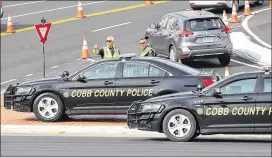  ?? CURTIS COMPTON PHOTOS / CCOMPTON@AJC.COM ?? Cobb Police Department officers work traffic control at the intersecti­on of Spring Road and Circle 75 Parkway outside the SunTrust Park developmen­t during a Braves game last spring.