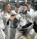  ?? Justin K. Aller Getty Images ?? JOSH HARRISON (5) of the Pirates is swarmed after his game-winning homer.