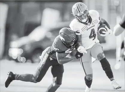  ?? JEFF MCINTOSH THE CANADIAN PRESS ?? Edmonton Eskimos' Tevaun Smith, right, is forced out of bounds by Calgary Stampeders' Raheem Wilson during second half CFL football action in Calgary on Saturday.