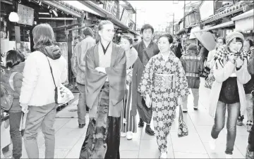  ??  ?? Thomas Kohler walks with participan­ts in the “Shibamata kimono group stroll” on the approach to the Shibamata Taishakute­n temple in Tokyo. — Japan News-Yomiuri photo