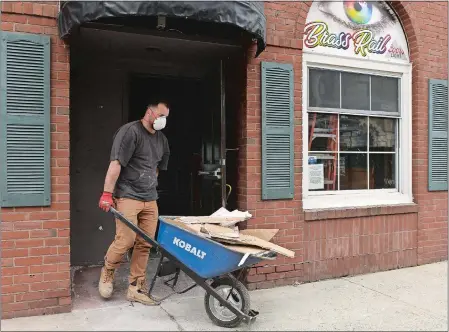  ?? DANA JENSEN/THE DAY ?? Sal D’Angelo, the new owner of the former Brass Rail, removes debris from the demolition inside Wednesday to a large dumpster at the curb in downtown New London. He plans on opening a restaurant in the building.