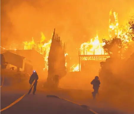  ?? Picture: RYAN CULLOM/VENTURA COUNTY FIRE DEPARTMENT VIA AP ?? Firefighte­rs work to put out a blaze burning homes in Ventura, California.