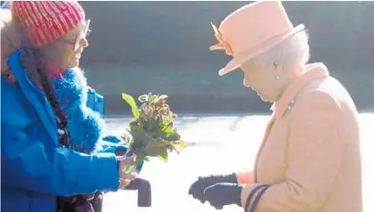  ?? Photo / Supplied ?? The last photo of Julia McCarthy-Fox with The Queen, presenting flowers from her Te Awamutu garden in 2019 at West Newton on the Sandringha­m Estate.