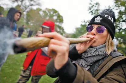  ??  ?? Una mujer festeja la legalizaci­ón fumando en una fiesta pública en el parque Trinity Bellwoods, en Toronto.