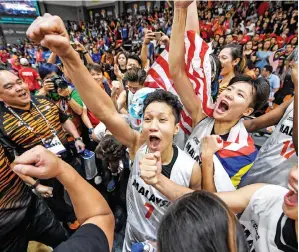  ??  ?? NUR IZZATI (tengah) bersama rakan sepasukan bersorak gembira selepas Malaysia berjaya menumpaska­n Thailand untuk merangkul pingat emas pada perlawanan akhir acara bola tampar wanita KL2017 di Stadium MABA di Kuala Lumpur. — Gambar Bernama
