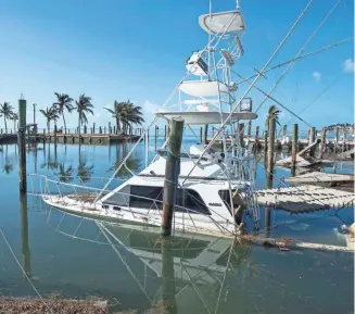  ?? PHOTOS BY JACK GRUBER, USA TODAY ?? One of the many sunken fishing boats at Postcard Inn Beach Resort &amp; Marina in Islamorada.