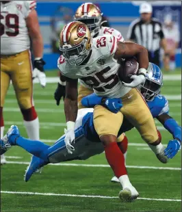  ?? KIRTHMON F. DOZIER/DETROIT FREE PRESS ?? 49ers running back Elijah Mitchell (25) runs by Detroit Lions defensive back Tracy Walker III on Sunday in Detroit.