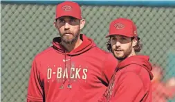  ?? ROB SCHUMACHER/THE REPUBLIC ?? Diamondbac­ks pitchers Madison Bumgarner, left, and Zac Gallen watch during a spring training workout at Salt River Fields on Wednesday.
