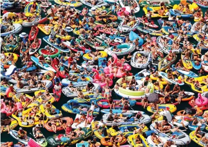  ?? Reuters ?? People on inflatable boats enjoy the weather on the Lake Lucerne in Sisikon, Switzerlan­d, on Sunday. —