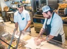  ?? STEVE SMITH/COURANT COMMUNITY ?? Head chef Peter Popowycz, left, and sous chef Aaron Bail prepare fresh sandwiches at Alltown Fresh in Bolton.