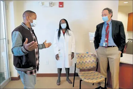  ?? NANCY LANE / BOSTON HERALD ?? Anthony Shivers, volunteer trial participan­t, talks with Dr. Paulette Chandler, lead of Community Engagement and Education, and Dr. Lindsey Baden, co-principal investigat­or and infectious diseases specialist, at Brigham and Women’s on Thursday in Chestnut Hill.