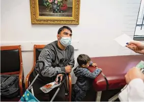  ?? Mark Mulligan/Staff file photo ?? Zamir Amiri, who brought his son Bilal to be examined at Hillcroft Physicians PA, shows a COVID-19 vaccinatio­n card to Dr. Forough Farizani last year.