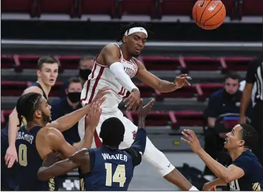  ?? (NWA Democrat-Gazette/J.T. Wampler) ?? Jalen Tate of Arkansas makes a pass under pressure against Oral Roberts during their December 2020 matchup, which the Razorbacks won 87-76. Arkansas will take on Oral Roberts in the NCAA Tournament Sweet 16 on Saturday, marking the ninth time the Razorbacks have faced a team in the NCAA Tournament that it also met during that regular season.