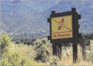  ?? AP PHOTO/SUSAN MONTOYA BRYAN ?? This June 30, image shows a sign prohibitin­g fireworks in the Sandia Mountains that border Albuquerqu­e, New Mexico.