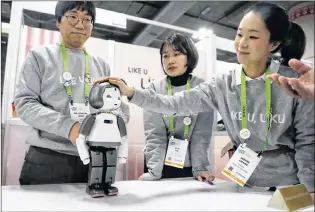  ?? AP PHOTO ?? Jaehee Chang, right, touches the Liku robot at the Torooc booth at CES Internatio­nal Wednesday in Las Vegas.