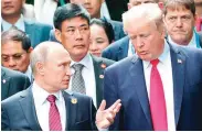  ??  ?? President Donald Trump, right, and Russia President Vladimir Putin talk during the family photo session at the APEC Summit in Danang. (Sputnik, Kremlin Pool Photo via AP)