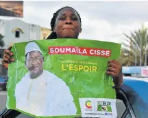  ?? Picture: AFP/ ISSOUF SANOGO ?? LOST CAUSE: A supporter of Malian presidenti­al candidate SoumaIila Cisse holds a poster of him.