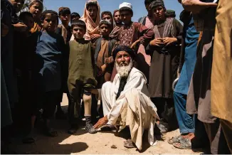  ??  ?? CHILDREN OF WAR [ TOP ] A father shows his son’s prosthetic leg, the result, he says, of a U.S. airstrike.
[ BOTTOM ] Local Taliban commander Tawakul, with his bodyguards. “The Taliban control the Kabul-Kandahar highway,” he says. “The Americans did their best, but this was what the socalled superpower was able to accomplish.”