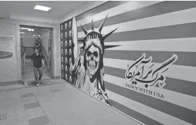  ?? VAHID SALEMI/AP ?? A man walks through the former U.S. Embassy, which has been turned into an anti-American museum in Tehran, Iran, on Aug. 19. The upcoming prisoner swap between Iran and the United States follows the same contours that the countries have tracing since the resolution of the 1979 U.S.