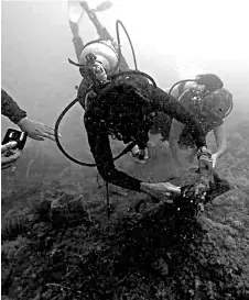  ??  ?? Divers collecting rubbish found underwater during the ‘gotong royong perdana’.