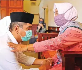  ?? FRIZAL/JAWA POS ?? SUNGKEMAN: Sebelum mendatangi KPU Surabaya, Mujiaman bersama istrinya, Acstantia Haqyafandr­i, sungkem dan memohon restu kepada sang ibu.