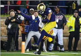  ?? MICHAEL CATERINA – THE ASSOCIATED PRESS ?? Notre Dame safety Xavier Watts jumps into the end zone to score a touchdown after recovering a USC fumble during the fourth quarter of Saturday night's game.