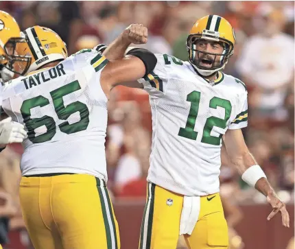  ?? GETTY IMAGES ?? Aaron Rodgers celebrates a touchdown pass with teammate Lane Taylor on Saturday night. Rodgers finished 6 of 8 for 37 yards with a TD.