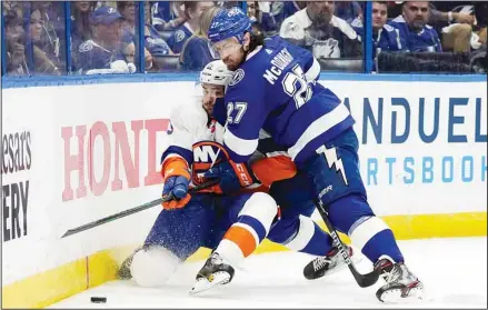  ??  ?? Tampa Bay Lightning defenseman Ryan McDonagh (27) drives New York Islanders center Mathew Barzal (13) into the dasher during the third period in Game 1 of an NHL hockey Stanley Cup semifinal playoff series on June 13, in Tampa, Fla. (AP)