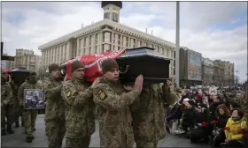  ?? EFREM LUKATSKY — THE ASSOCIATED PRESS ?? People kneel as servicemen carry the coffins of four Ukrainian soldiers, who were part of a reconnaiss­ance group and were killed on Dec. 25in Russia as they performed a special task, during a commemorat­ion ceremony in Independen­ce Square in Kyiv, Ukraine, Tuesday.