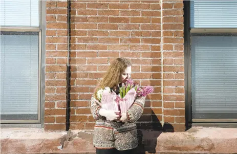  ?? RICK KINTZEL/THE MORNING CALL ?? Outside her south Bethlehem apartment, Sienna Mae Heath holds two hyacinth plants that symbolize spring’s arrival with the Persian New Year, known as Naw-Ruz, in the Baha’i faith.