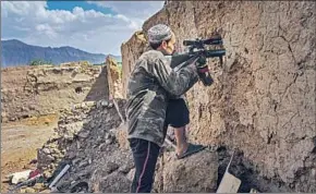  ??  ?? AZIMULLAH MUHAMADI, 23, peeks through a makeshift crenel with a sniper scope to survey where security forces hold the line against the Taliban on May 4 in Panjwayi.