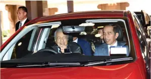  ?? BPMI SETPRES/MUCHLIS JR ?? ULANG MOMEN 2015: Presiden Jokowi naik mobil Proton Persona warna merah yang dikemudika­n Perdana Menteri (PM) Malaysia Mahathir Mohamad dari Perdana Putra Building, Putrajaya, kemarin.