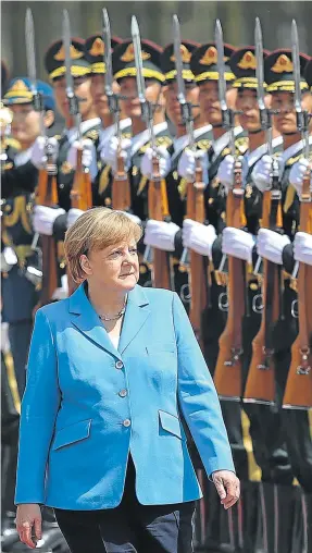  ?? Picture: AFP ?? STANDING HER GROUND: German Chancellor Angela Merkel to reviews an honour guard during a welcoming ceremony outside the Great Hall of the People yesterday in Beijing, China