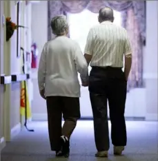  ?? Matt Rourke/Associated Press ?? An elderly couple walk down a hall in Easton, Pa., in 2015. A new study suggests if you want to save your brain from dementia, keep the rest of your body well with exercise.