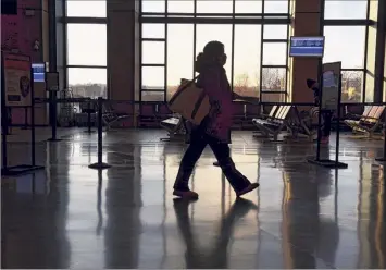  ?? Will Waldron / Times Union ?? A masked passenger on Thursday walks through the Albany-rensselaer Amtrak station in Rensselaer. The majority of Thanksgivi­ng travelers will be going by car this holiday.